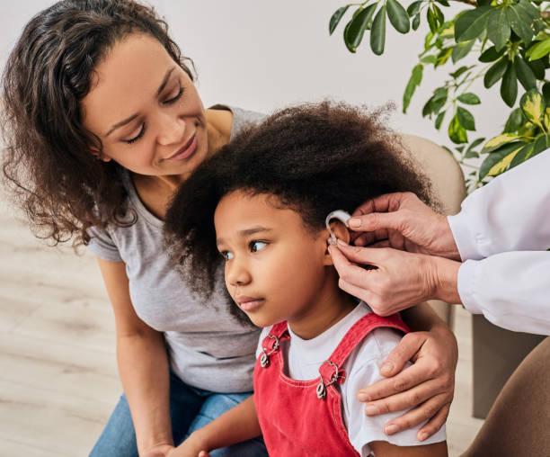 Child with parent receiving a listening device