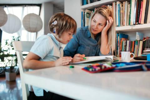 Image of a student with a listening device being taught by a teacher.