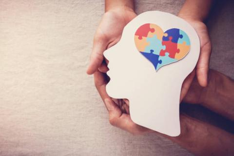 image of two pairs of hands holding the image of a head with a puzzle in the shape of a heart