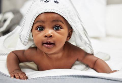 image of baby staring at camera and with blanket over his head