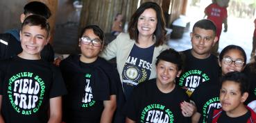 Image of Superintendent Copher at Kids' Day 2025 posing with several students who attended.